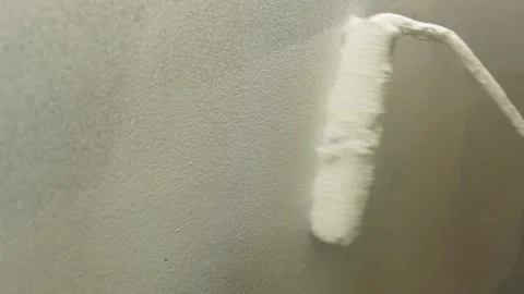 The roller smoothly applies paint to the wall. Stock Footage 300369639
