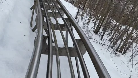 Rollercoaster track winding through snowy landscape Stock Footage 297675121