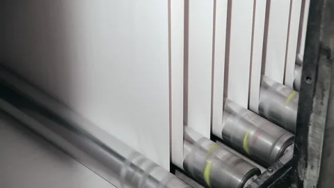 Rollers of commercial printing press spin and move paper through the Stock Footage 133399590