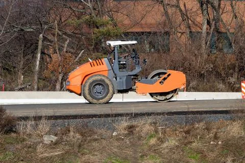 Rollers rolling fresh hot asphalt on the new road road construction Stock Photos