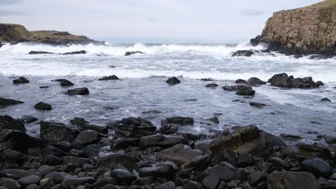 Rolling Atlantic Ocean Waves racing to shore at Dunseverick Vídeos de archivo 303451487