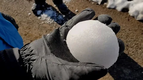 Rolling big snowball in gloved hand in slow motion. Stock Footage 98175040