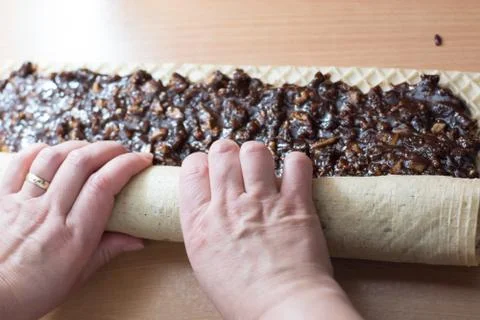 Rolling cake crust with chocolate and jelly candies. Stock Photos