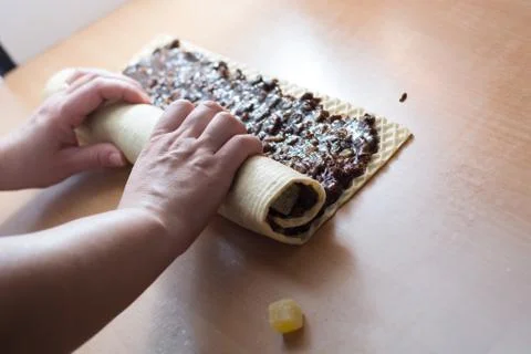 Rolling cake crust with chocolate and jelly candies. Stock Photos
