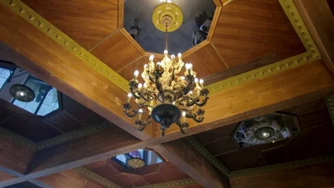Rolling camera shot with an antique design chandelier hanging from ceiling Stock Footage 155842795