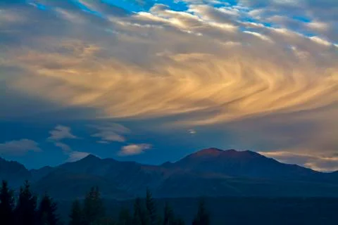 Rolling clouds above mountains before sunset Stock Photos
