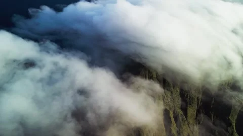 Rolling Clouds Covering Mountain Slopes with Green Terrain in Soft Daylight Stock Footage 335314793