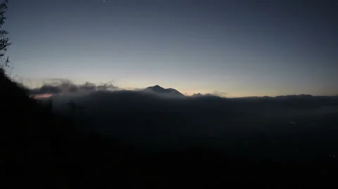 Rolling clouds give way to sunrise over the strato-volcano Mount Agung in Bali Stock Footage 61040353