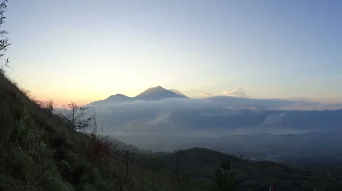 Rolling clouds give way to the sunrise over Mount Agung in Bali Stock Footage 61041948