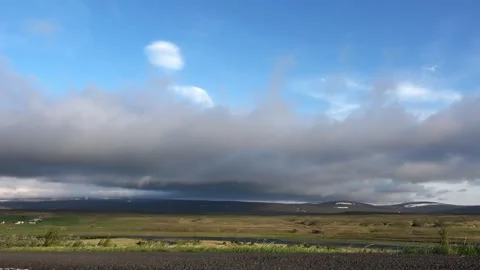Rolling clouds moving over a vast green and volcanic landscape in the Icelandic 库存影片 346325884