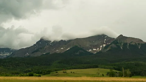 Rolling clouds over a mountain peak Stock Footage 154899715