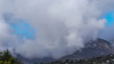 Rolling clouds over riviera style residential mountain range 4k 24fps Stock Footage 132874325