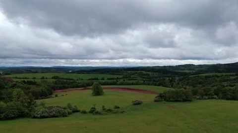 Rolling Countryside with Cloudy Sky and Green Fields Stock Footage 310801108