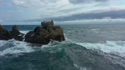 Rolling Crashing Waves Splashing Against Lava Rock in Black Sea Stock Footage 179355923