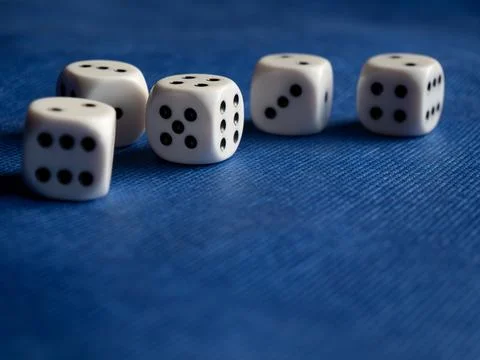 Rolling Dice on a Vibrant Blue Background Stock Photos