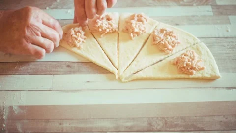 Rolling up dough into crescent rolls close up, shaping homemade savory Stock Footage 337877741