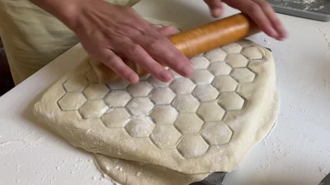 Rolling dough in dumpling mold with filling inside Stock Footage 315345816