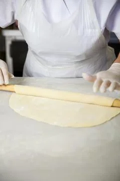 Rolling dough in a kitchen for baking pastries and bread 库存照片