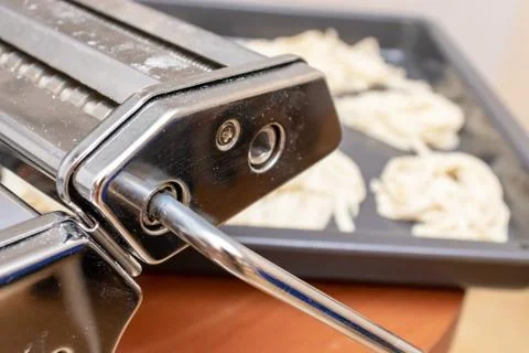 Rolling dough machine fo making pasta and ravioli close up with homemade ribb Stock Photos