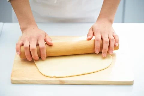 Rolling the dough with a rolling pin, bread making process Foto stock