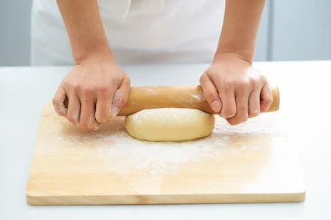 Rolling the dough with a rolling pin, bread making process Foto stock
