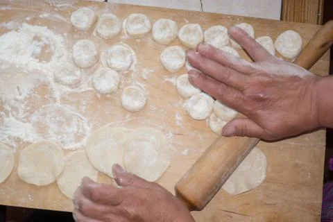 Rolling the dough with a rolling pin. Stock Photos