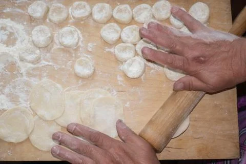 Rolling the dough with a rolling pin. Stock Photos