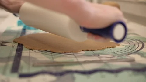 Rolling the dough by rolling pin. Slow motion close up shot on a gimbal. Stock Footage 122527241