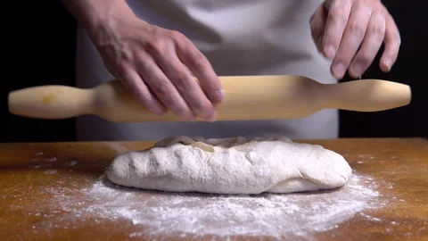 Rolling the dough with a rolling pin on the table. close-up 4K Stock Footage 111729483