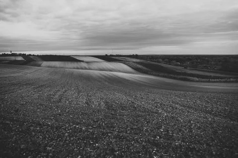 Rolling fields under a cloudy sky at dusk Stockfoto's