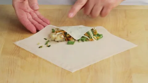 Rolling up filling in a spring roll wrapper Stock-Footage 24666631