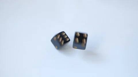 Rolling a five and a one with a pair of black gambling dice on a white table in Stock Footage 109150149