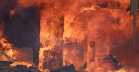 Rolling flames consume an interior wall of a burning house and debris falls from Stock Footage 59227581