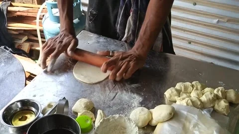 Rolling fresh dough on a floured metal surface in a rustic kitchen Stock Footage 324607007