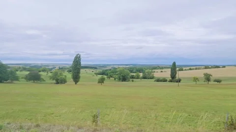 Rolling Green Countryside Beneath Layered Cloudy Sky Stock Footage 345718689