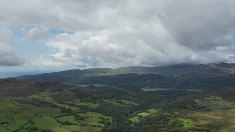 Rolling green hills and valleys under dramatic cloudy skies. Stock Footage 314347560