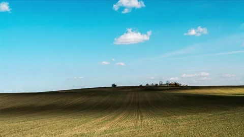 Rolling Green Hills Under a Clear Blue Sky with moving Clouds Stock Footage 305766441