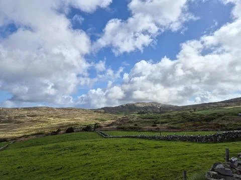 Rolling green hills under dramatic cloudy sky Fotos Stock
