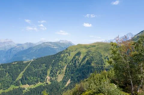 Rolling green ridges with distant alpine peaks Stock Photos