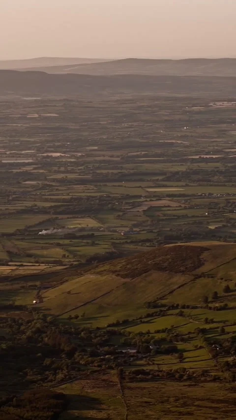 Rolling hills and patchwork fields stretch into the horizon Stock Footage 329385483