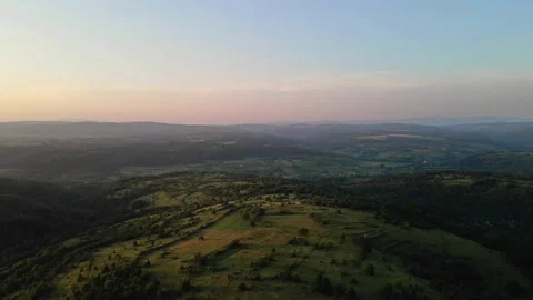 Rolling hills with woods and fields in early morning warm light Stock Footage 262837494