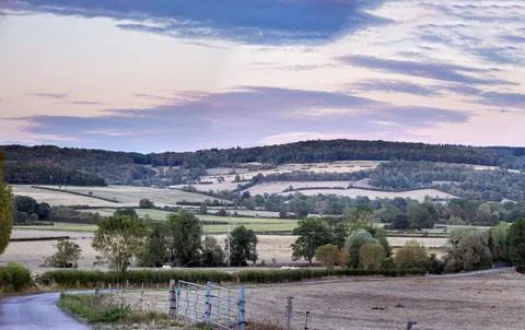 Rolling hills yellow fields and distant castle under cloudy sky in Burgundy.. Stock Photos