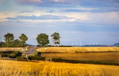 Rolling hills yellow fields and distant castle under cloudy sky in Burgundy.. Stock Photos