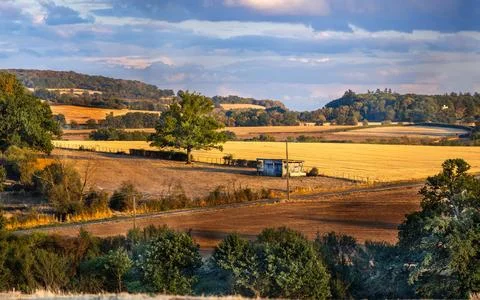Rolling hills yellow fields and distant castle under cloudy sky in Burgundy.. Stock Photos