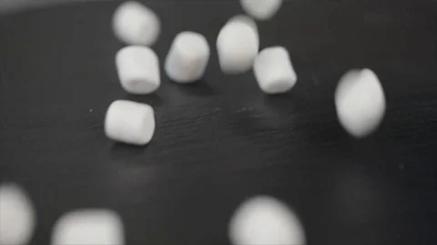 Rolling Marshmallows on Black Underground Closeup Stock Footage 99163905