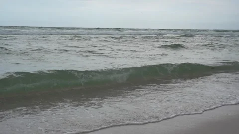 Rolling ocean waves and surf on a sandy beach shore Stock Footage 345689583
