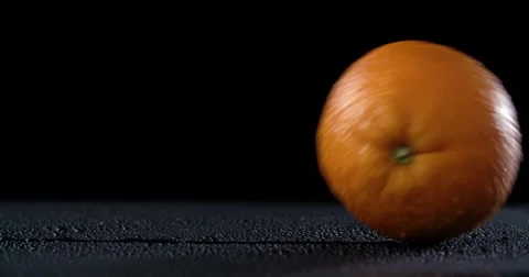 Rolling orange on dark background Stock Footage 58303070