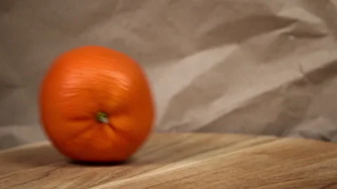 Rolling Orange on Wooden Surface Stock Footage 264770982