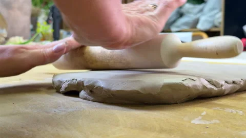 Rolling out clay sheet with a rolling pin to prepare base for plaster relief wit Stock Footage 314186070