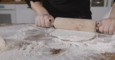 Rolling out a dough female hand using rolling pin in slow motion in restaurant Stock Footage 124876190
